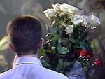 Бутусов поет с букетом белых роз в руке (вил сзади)